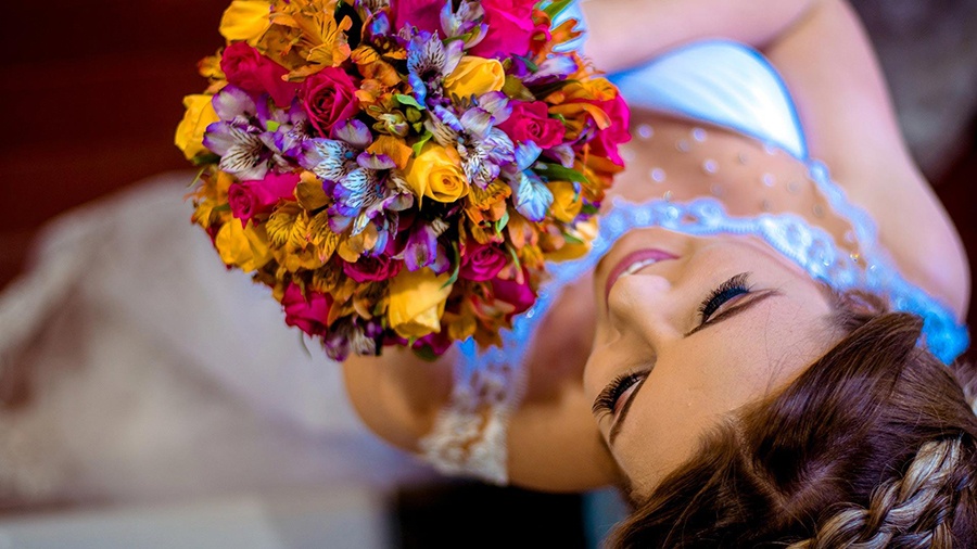 Foto de cima focando na noiva com buquê de casamento colorido