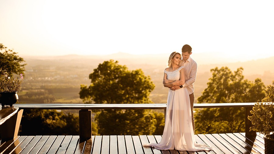 Casal em uma varanda com natureza ao fundo